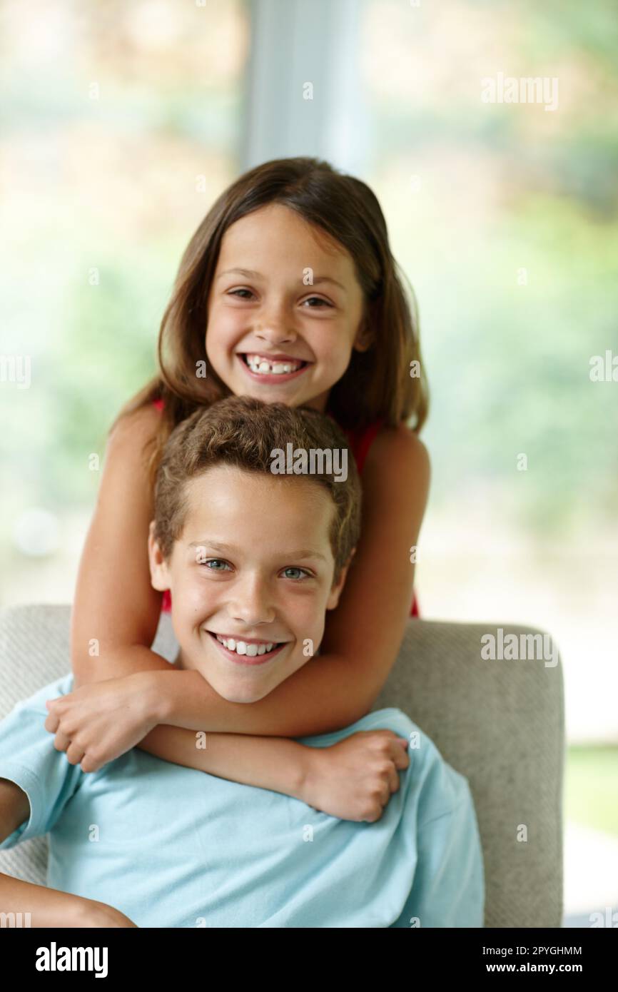 Vanno bene. una bambina che abbraccia il fratello da dietro. Foto Stock