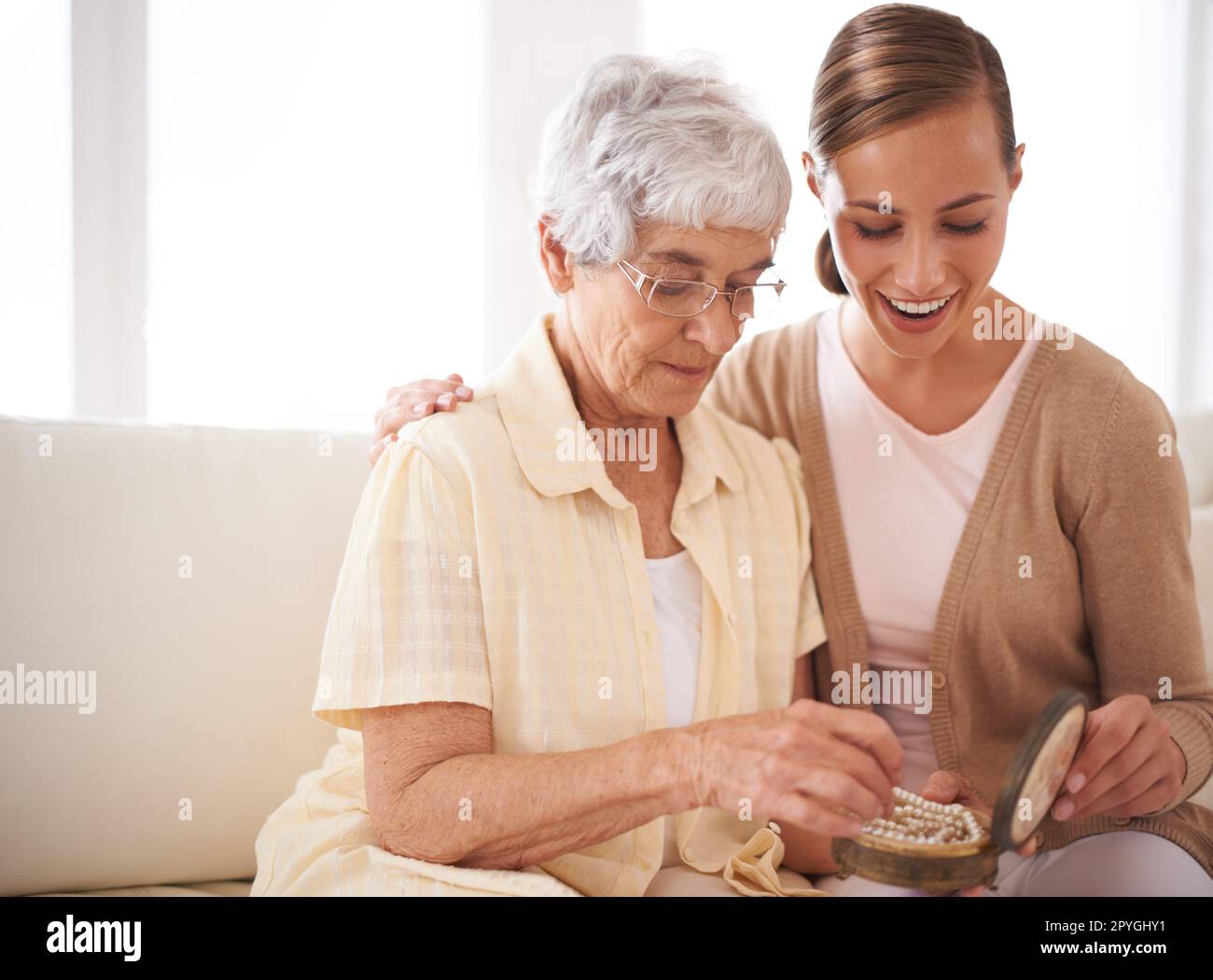 Momenti materni. una donna anziana che dona alla figlia una collana di perle. Foto Stock