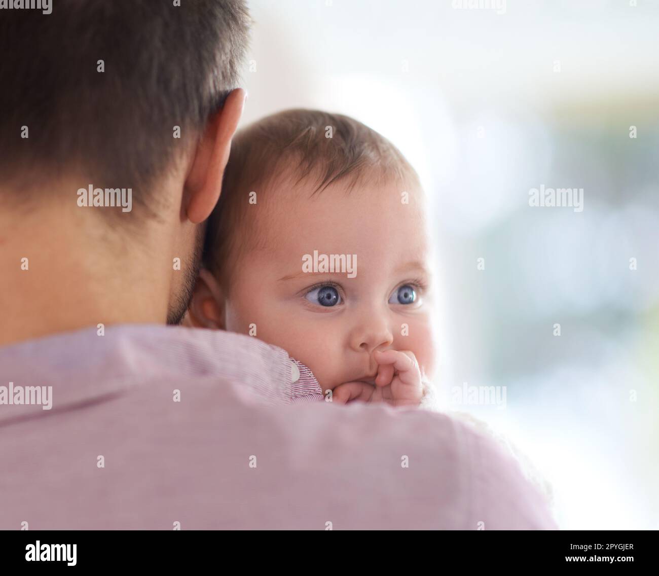 Daddys piccolo angelo. una bambina che guarda sopra la spalla dei suoi padri. Foto Stock