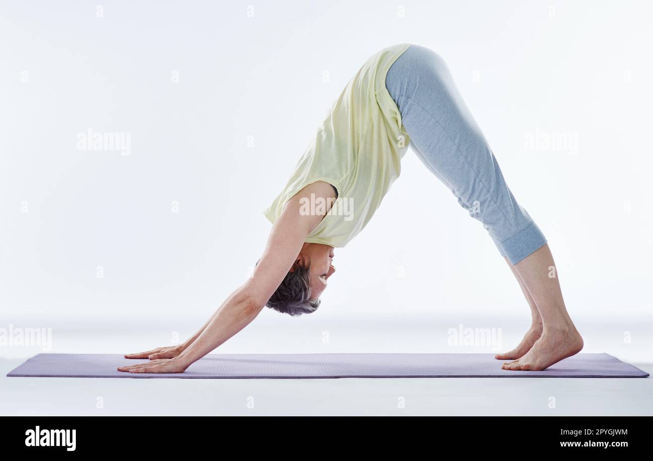 Stretching la schiena. Scatto completo di una donna attraente che si allunga prima dello yoga. Foto Stock