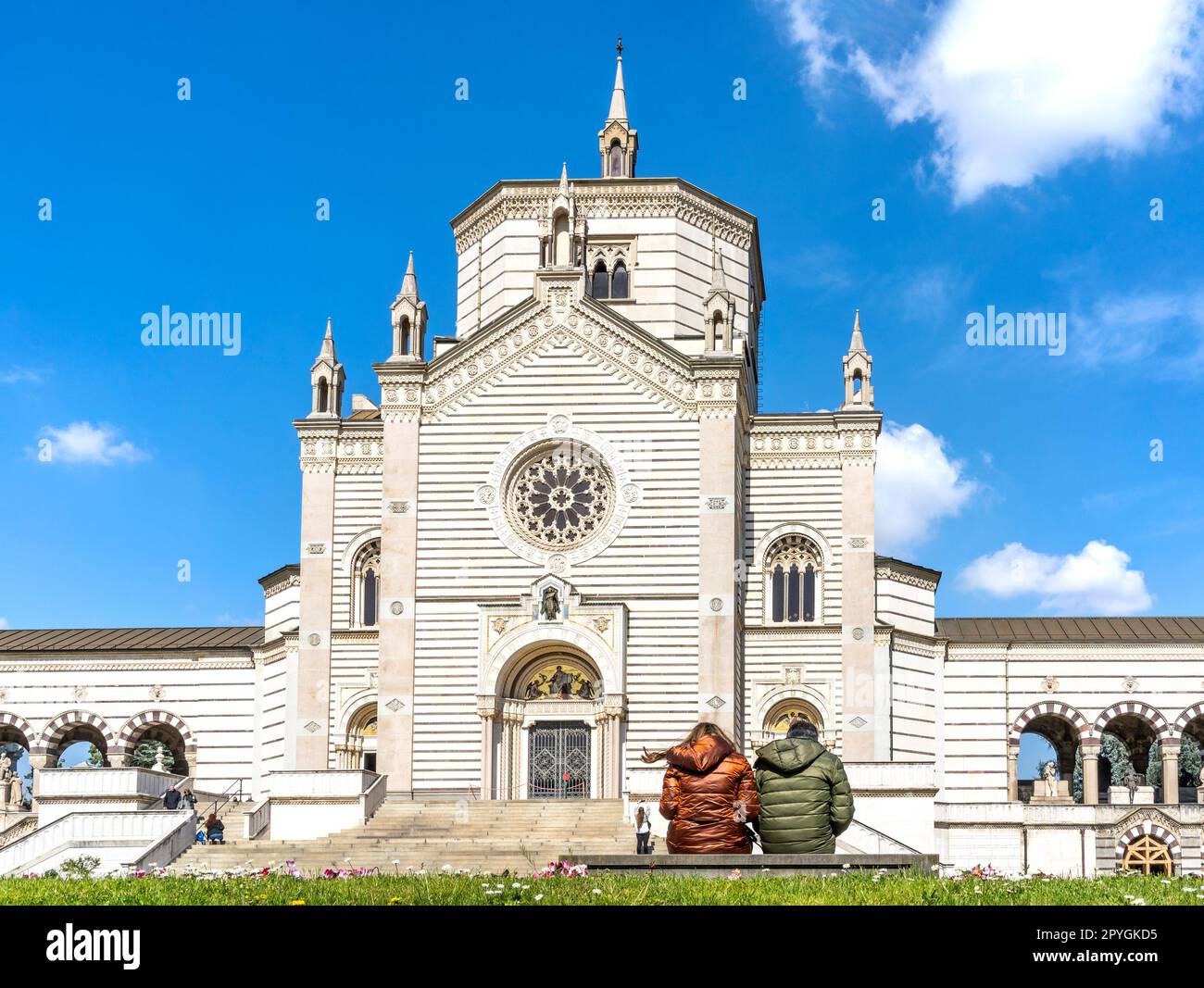Esterno del Fammedio, sala del Cimitero Monumentale di Milano dove sono sepolte molte persone di rilievo, con due persone sedute su una panchina. Foto Stock