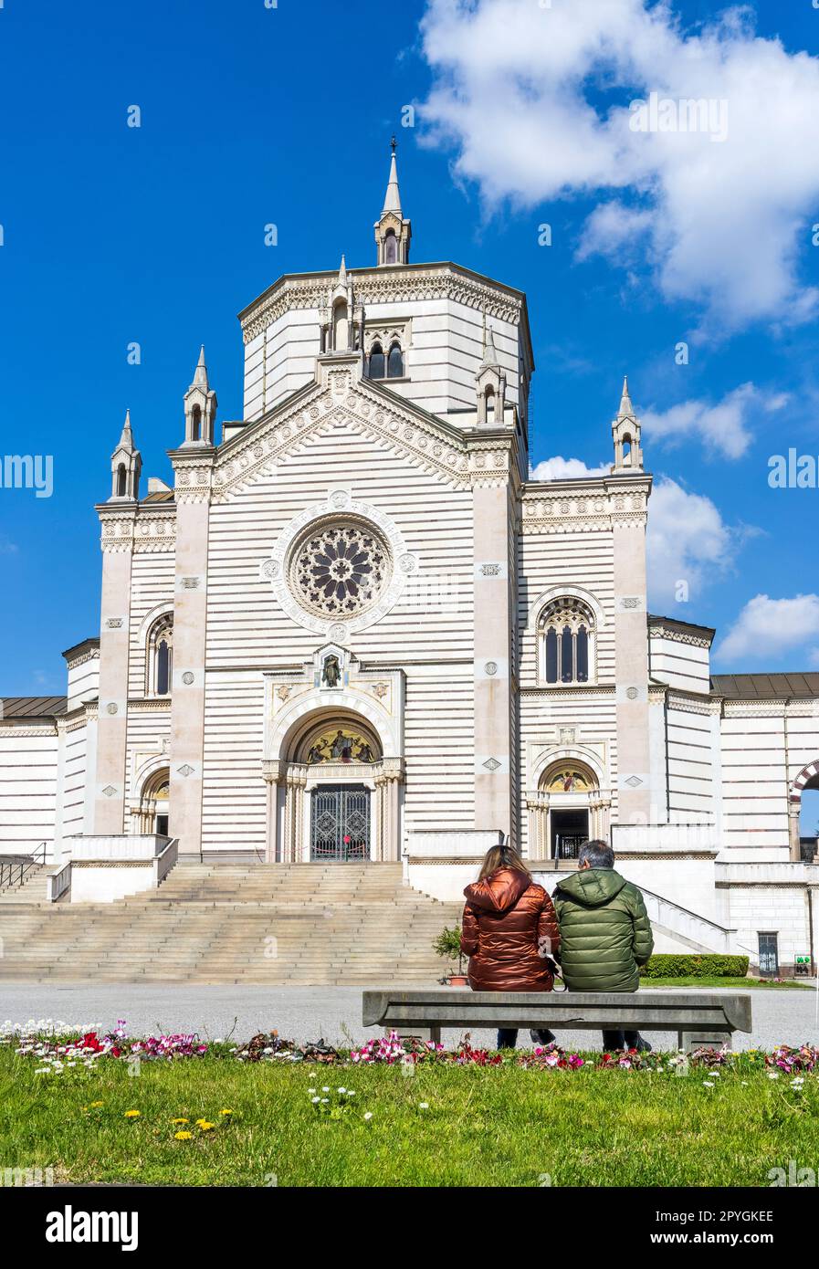 Esterno del Fammedio, sala del Cimitero Monumentale di Milano dove sono sepolte molte persone di rilievo, con due persone sedute su una panchina. Foto Stock
