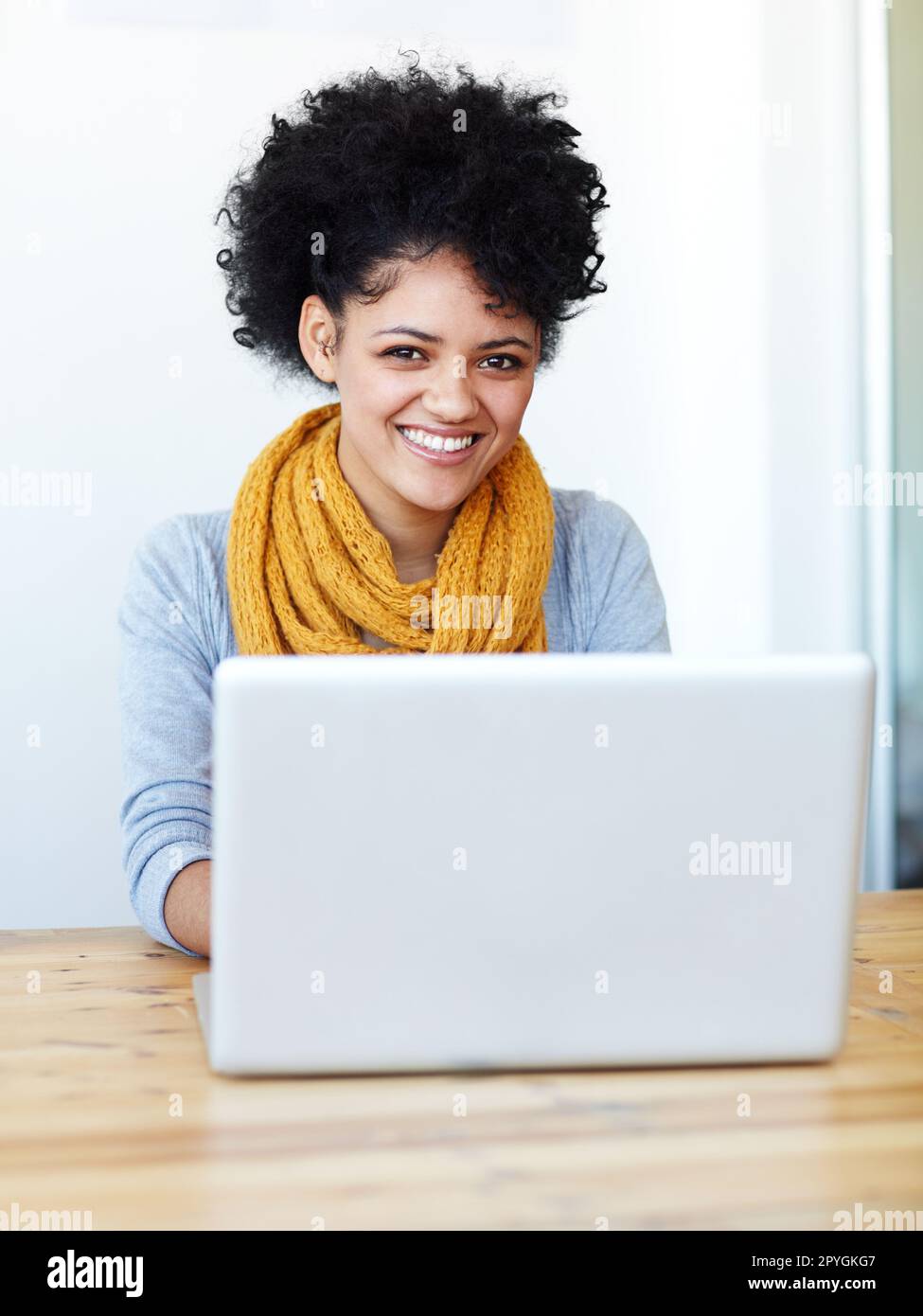 Navigare sul Web. Una giovane donna attraente seduta al suo laptop. Foto Stock