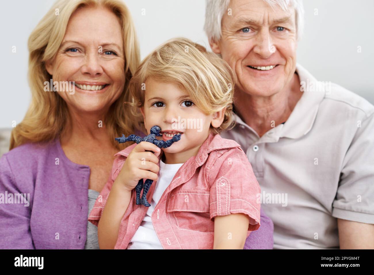 Ci ricorda i bei vecchi giorni. una coppia anziana seduta con il loro adorabile nipote. Foto Stock