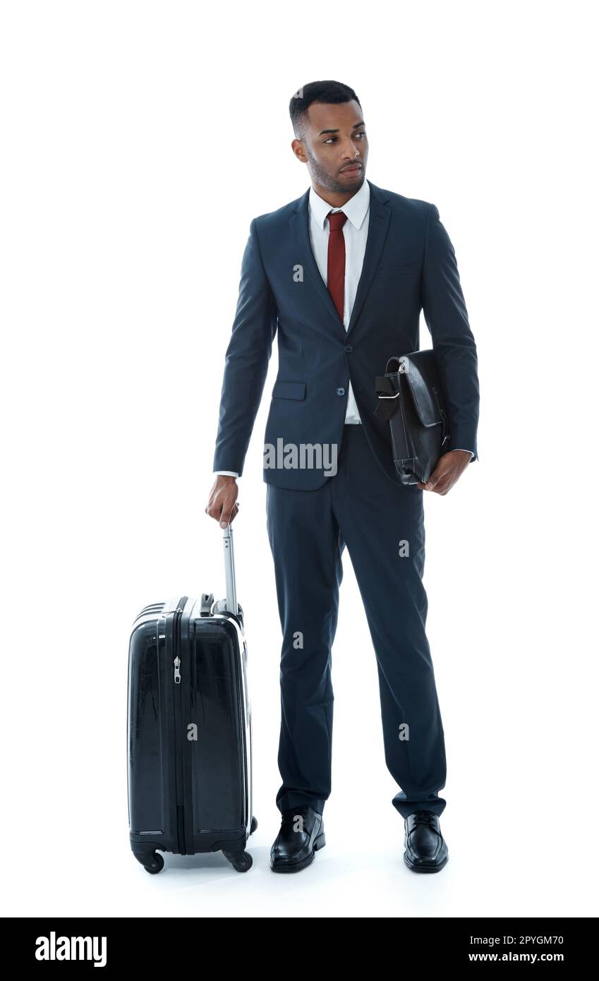 In attesa del suo treno. Un bel giovane uomo d'affari afroamericano in piedi accanto alla sua valigia mentre isolato sul bianco. Foto Stock