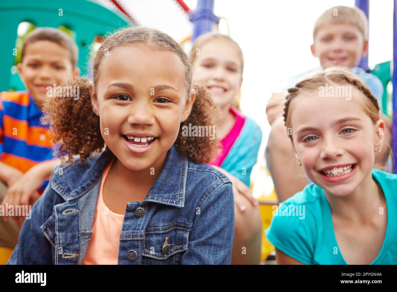 Speranza per il futuro. Un gruppo multietnico di bambini felici che giocano in una palestra nella giungla in un parco giochi. Foto Stock