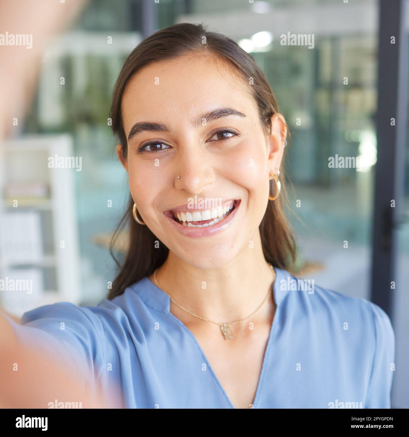 Felice, ritrattista o donna d'affari che scatta un selfie nell'edificio di uffici per una foto del profilo dei social media e sorride con orgoglio. Volto, foto o manager con obiettivi, mentalità di successo o motivazione al lavoro Foto Stock