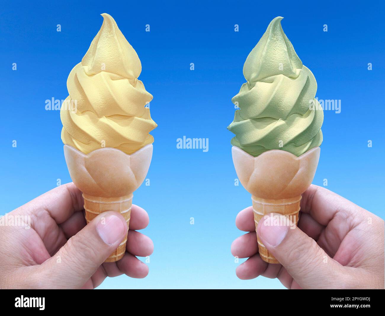 Mano dell'uomo che tiene un cono del gelato sullo sfondo. il cielo blu Foto Stock