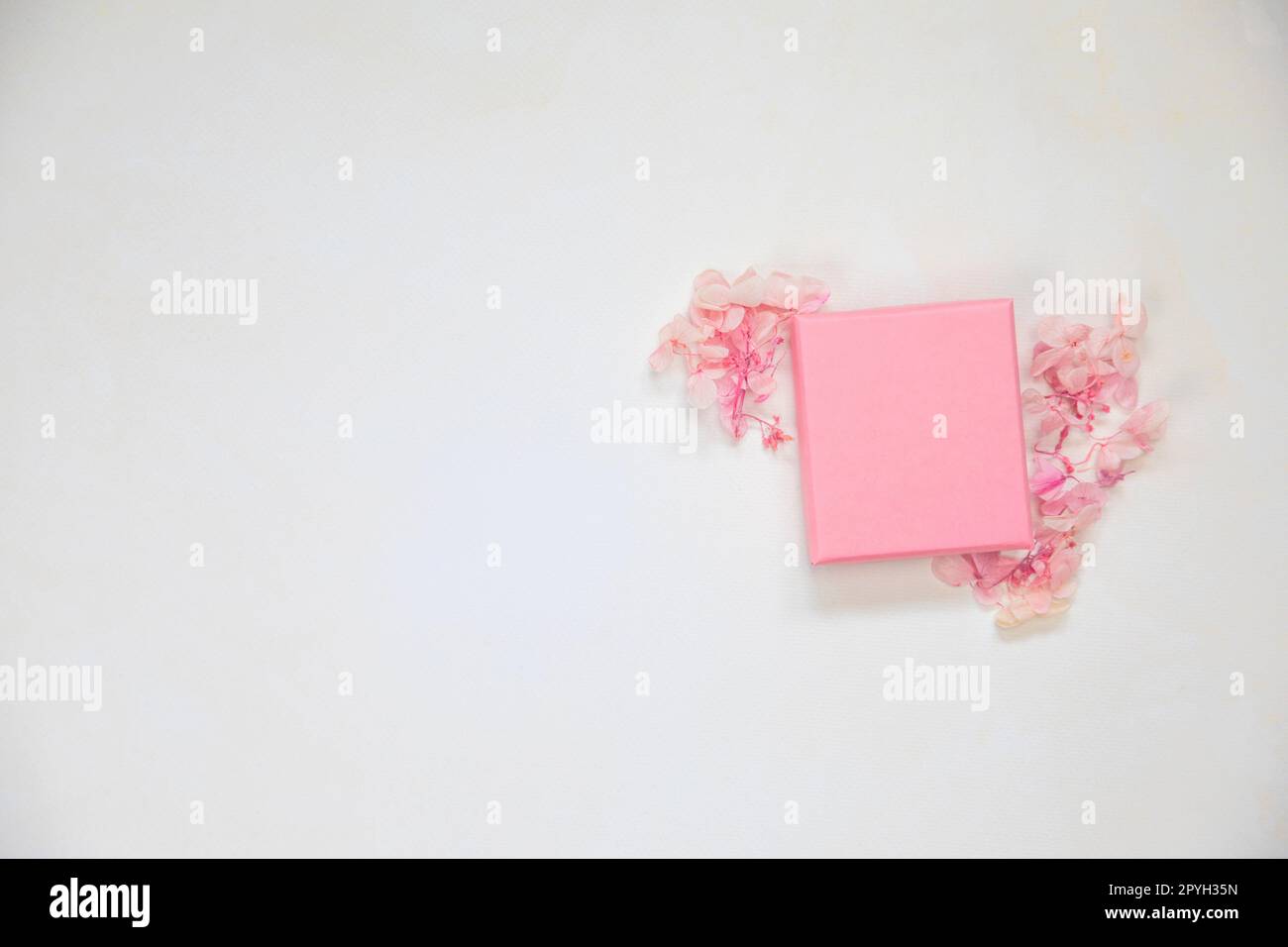 Scatola regalo rosa aperta e chiusa per il prodotto su sfondo luminoso con fiori. Piano, vista dall'alto, regalo mock-up, regalo della mamma, San Valentino, concetto di compleanno Foto Stock