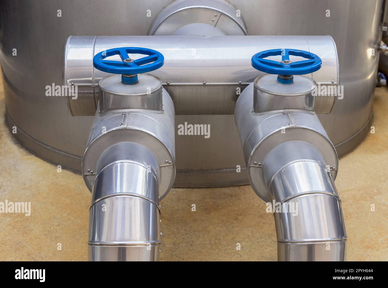 Valvole e tubi in metallo blu di tipo volantino, apparecchiature industriali presso la fabbrica di vino, primo piano Foto Stock