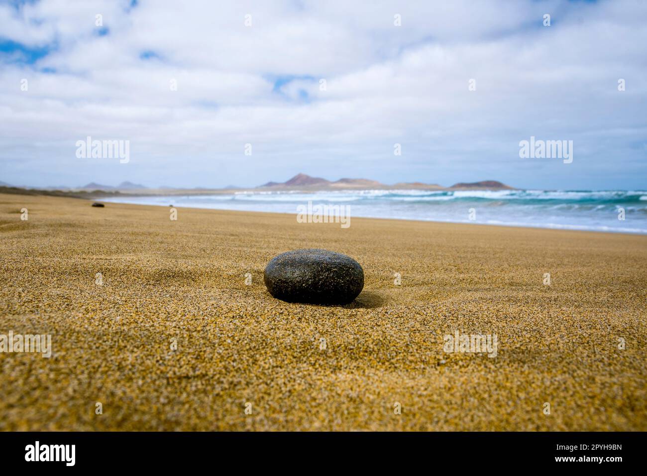 Spiaggia vuota con pietra nera in primo piano Foto Stock