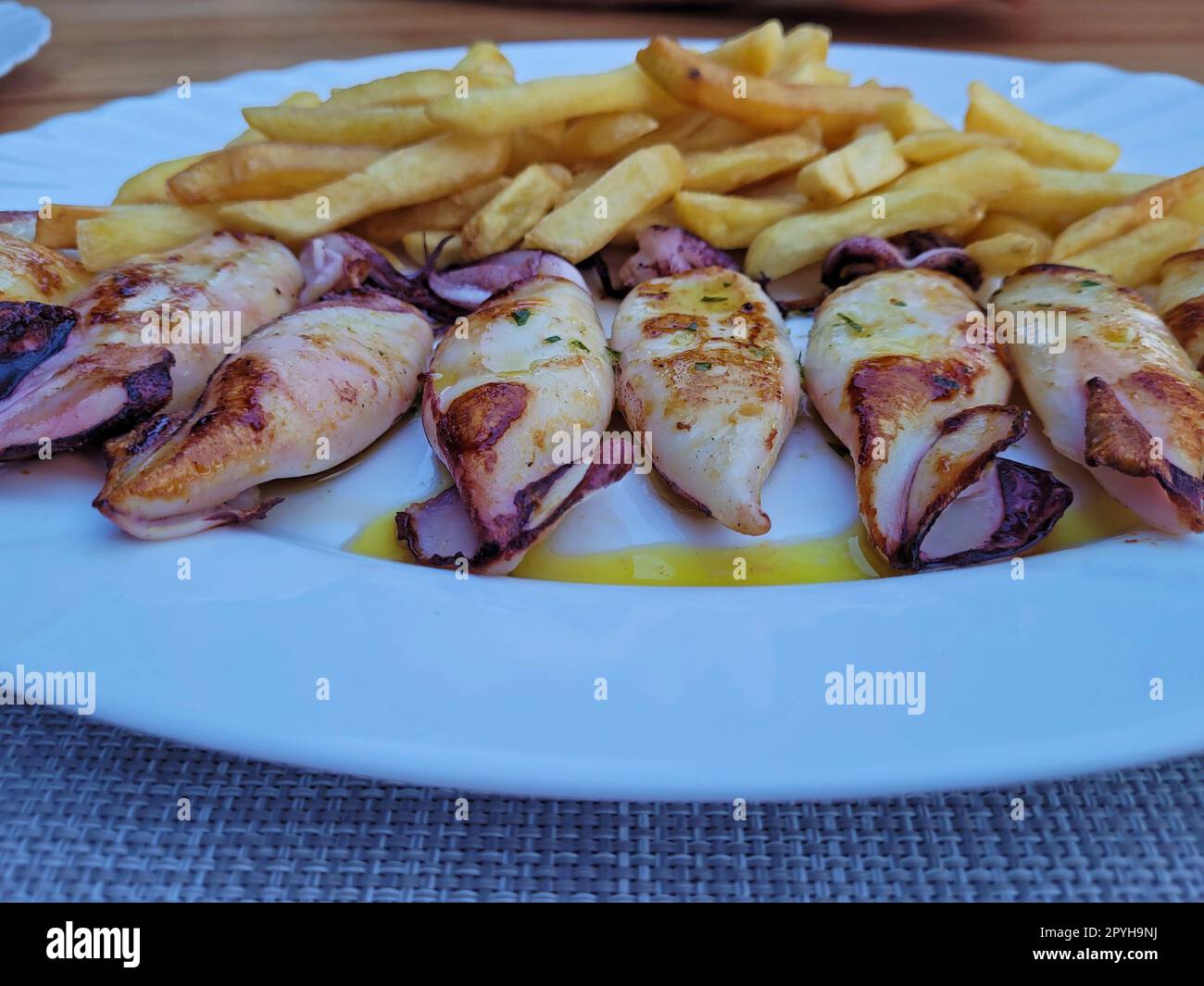 piatto con calamari e patatine grigliate Foto Stock