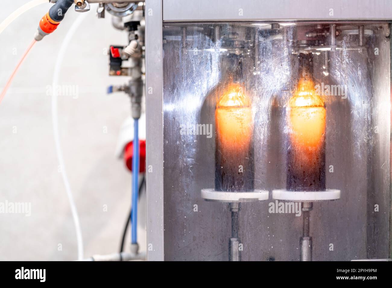 macchina per il lavaggio e il riempimento di bottiglie di vetro con birra Foto Stock