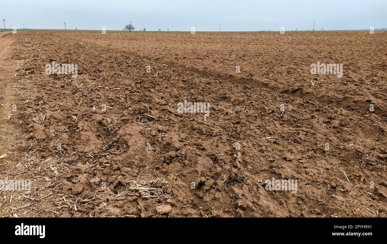 Campo appena arato. Seminativi con terreno fertile per la piantagione di grano. Paesaggio rurale in Serbia, nei Balcani, in particolare Fruska Gora di Sremska Mitrovica. Solchi e pozzi. Lavori agricoli preparatori Foto Stock