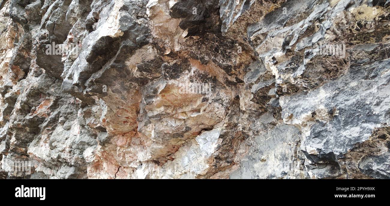 Primo piano di pietra a Sarajevo, Bosnia ed Erzegovina. Antica lava ghiacciata. Strati e strati di rocce. Montagna dopo un'esplosione guidata per posare la strada. Consistenza della pietra. Colori grigio e beige Foto Stock
