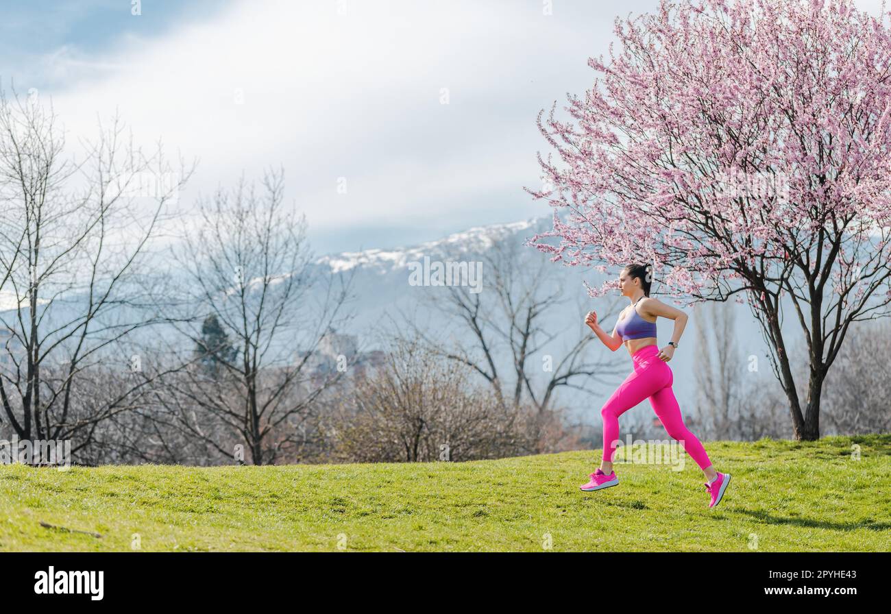 Donna in corsa per il fitness in un giorno di primavera Foto Stock