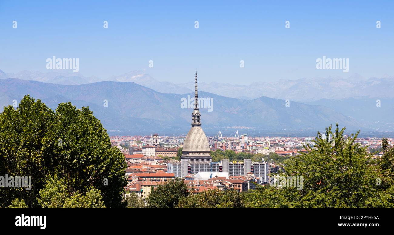 Torino - Italia - skyline urbano con edificio Mole Antonelliana, cielo blu e montagne alpine. Foto Stock