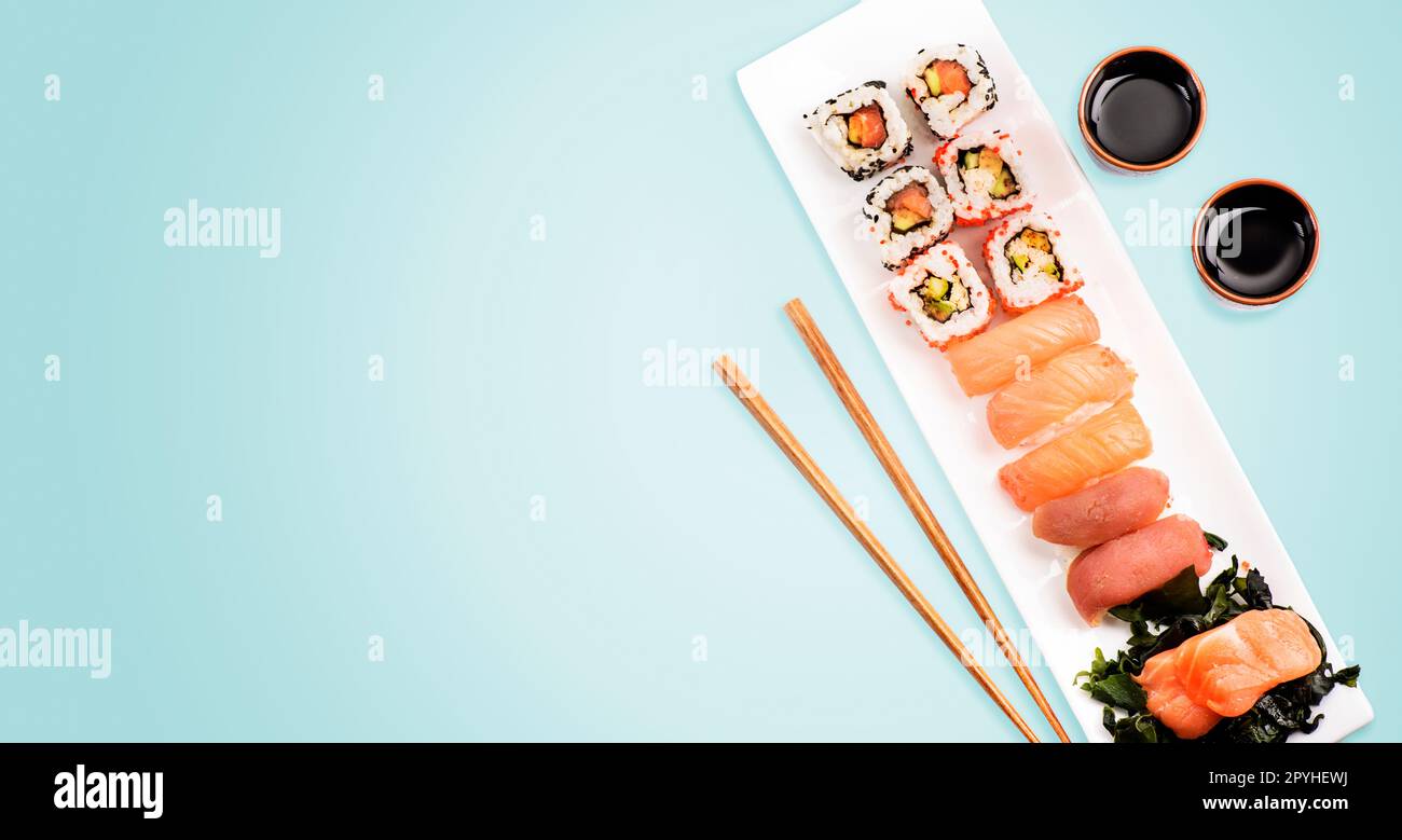 Panini sushi con salmone e tonno su sfondo azzurro dall'alto. Foto Stock