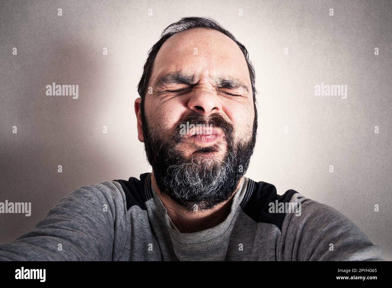 Uomo divertente con la barba che fa espressioni Foto Stock