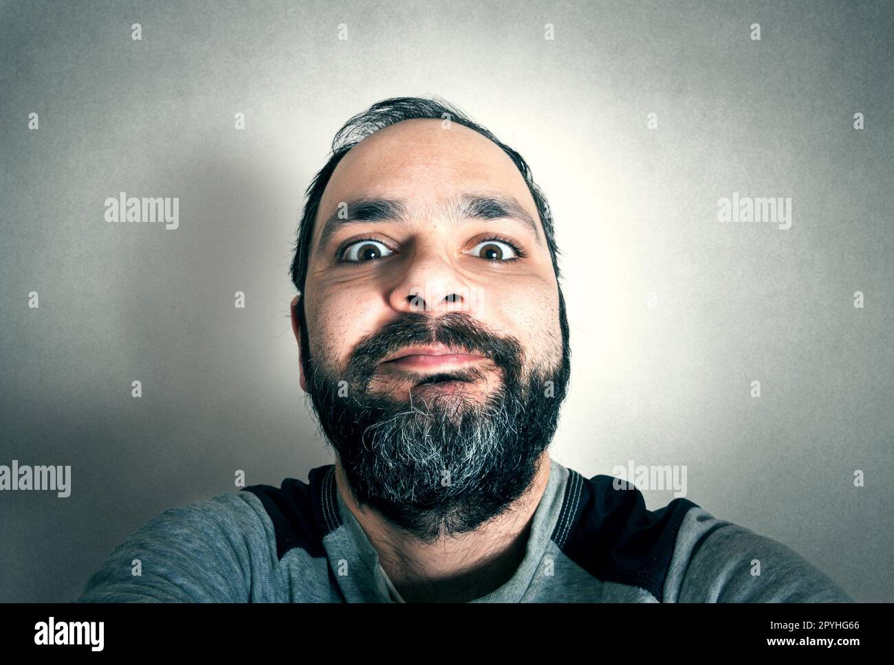 Uomo divertente con la barba che fa espressioni Foto Stock