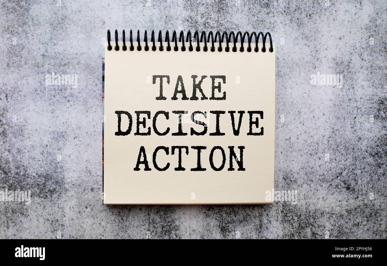 Economia e business concept. Sulla tabella sono riportate le relazioni, le matite e un quaderno con l'iscrizione - PRENDERE UN'AZIONE DECISIVA Foto Stock