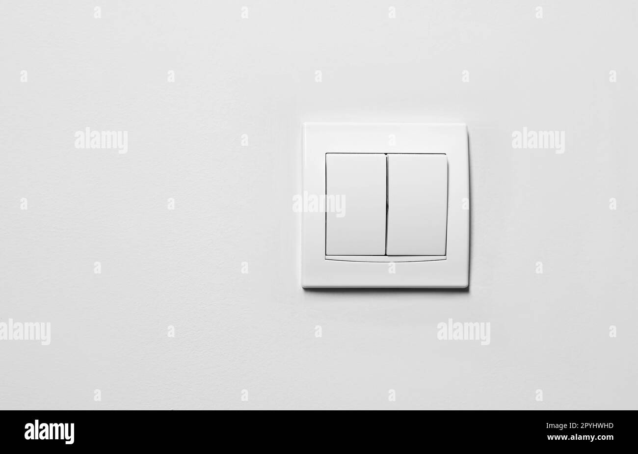 Moderno interruttore di luce in plastica su parete bianca, spazio per il testo Foto Stock