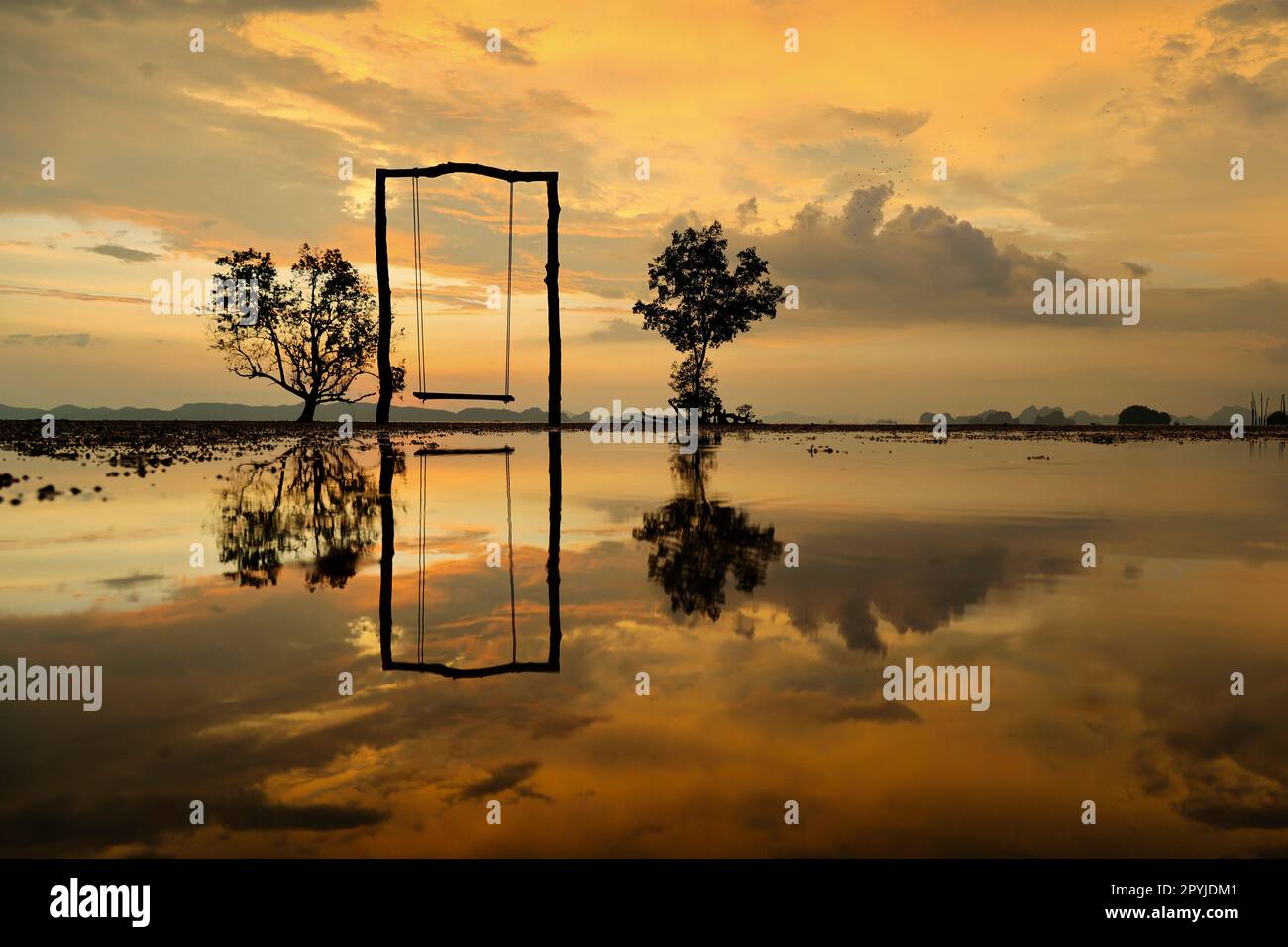 Tramonto con riflesso di altalena e alberi nella baia di Ao thalane-Thailandia Foto Stock