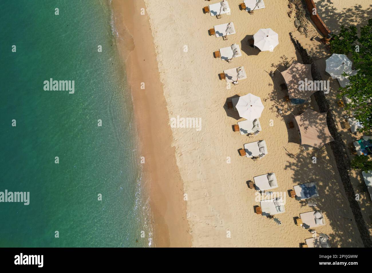 vista aerea con drone, di spiaggia di sabbia bianca tropicale, con lettini e ombrelloni Foto Stock