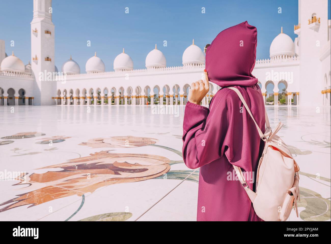 I visitatori della Grande Moschea dello Sceicco Zayed sono colpiti dalla serenità e dalla tranquillità dei loro dintorni. Foto Stock