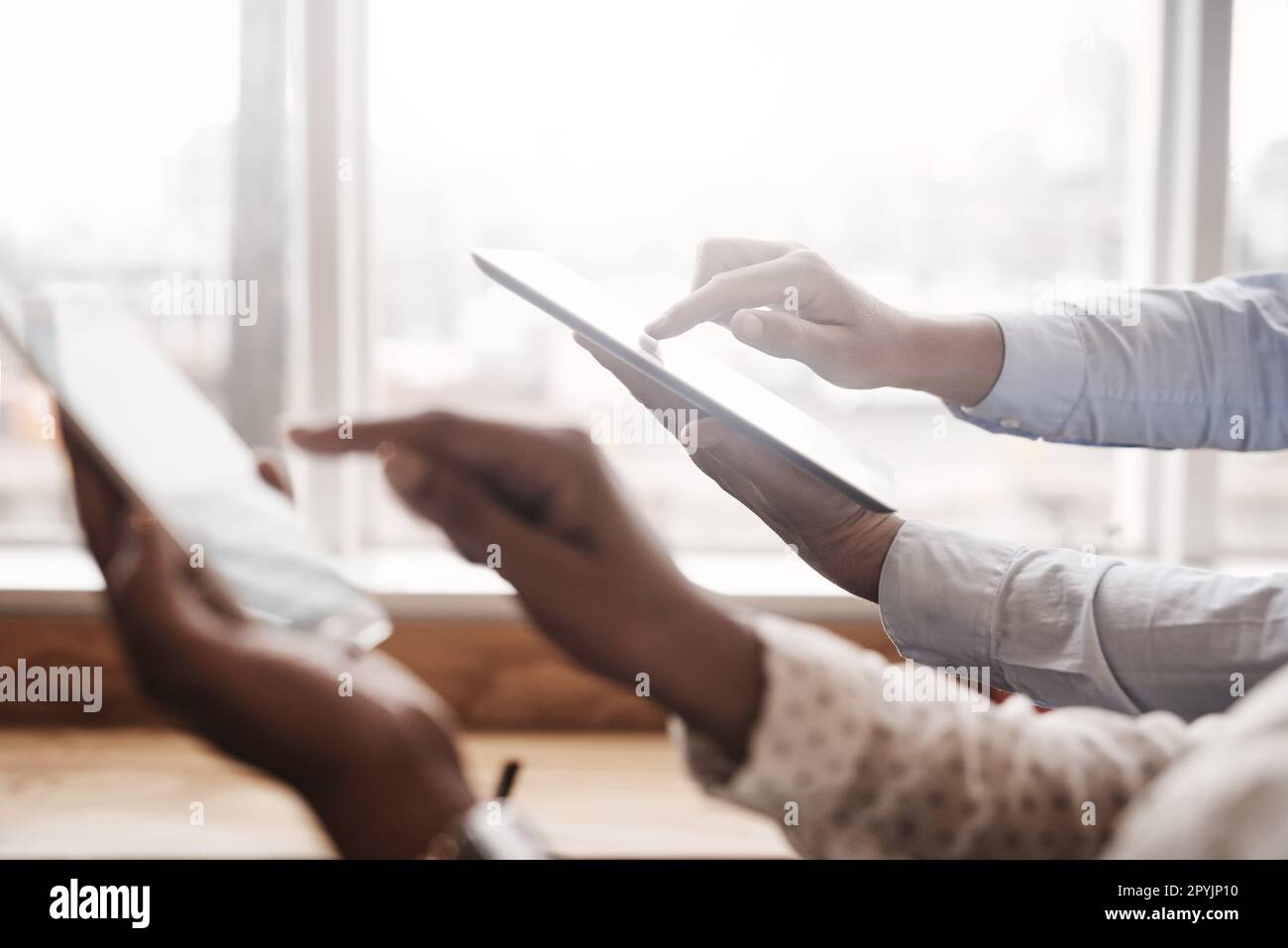 Gestire il business tramite app intelligenti. Primo piano di due uomini d'affari irriconoscibili che utilizzano dispositivi digitali in un ufficio. Foto Stock