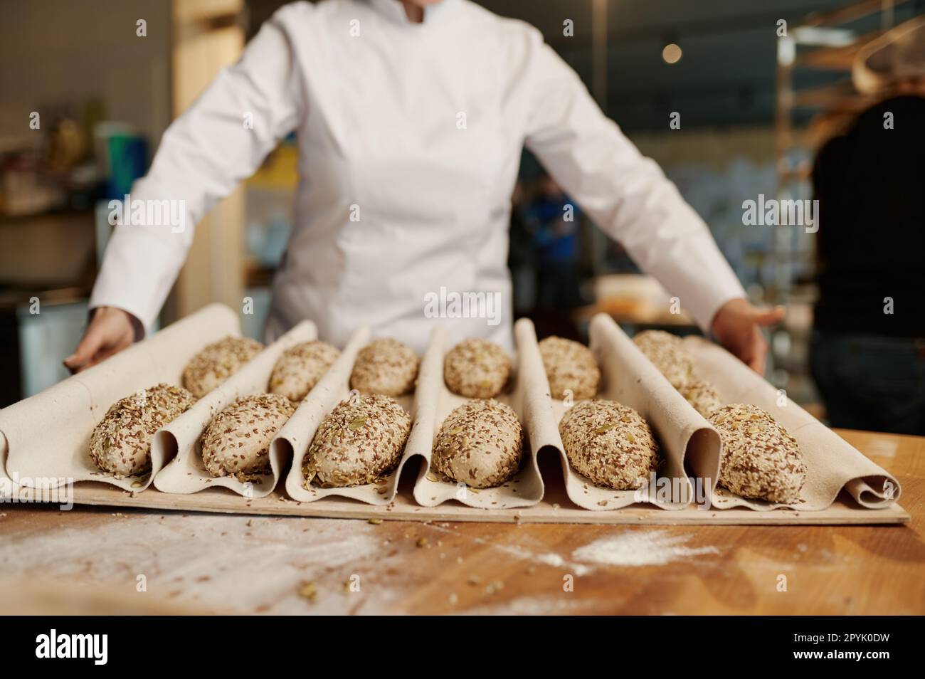 Panettiere preparare dolci a base di panini con semi di sesamo Foto Stock