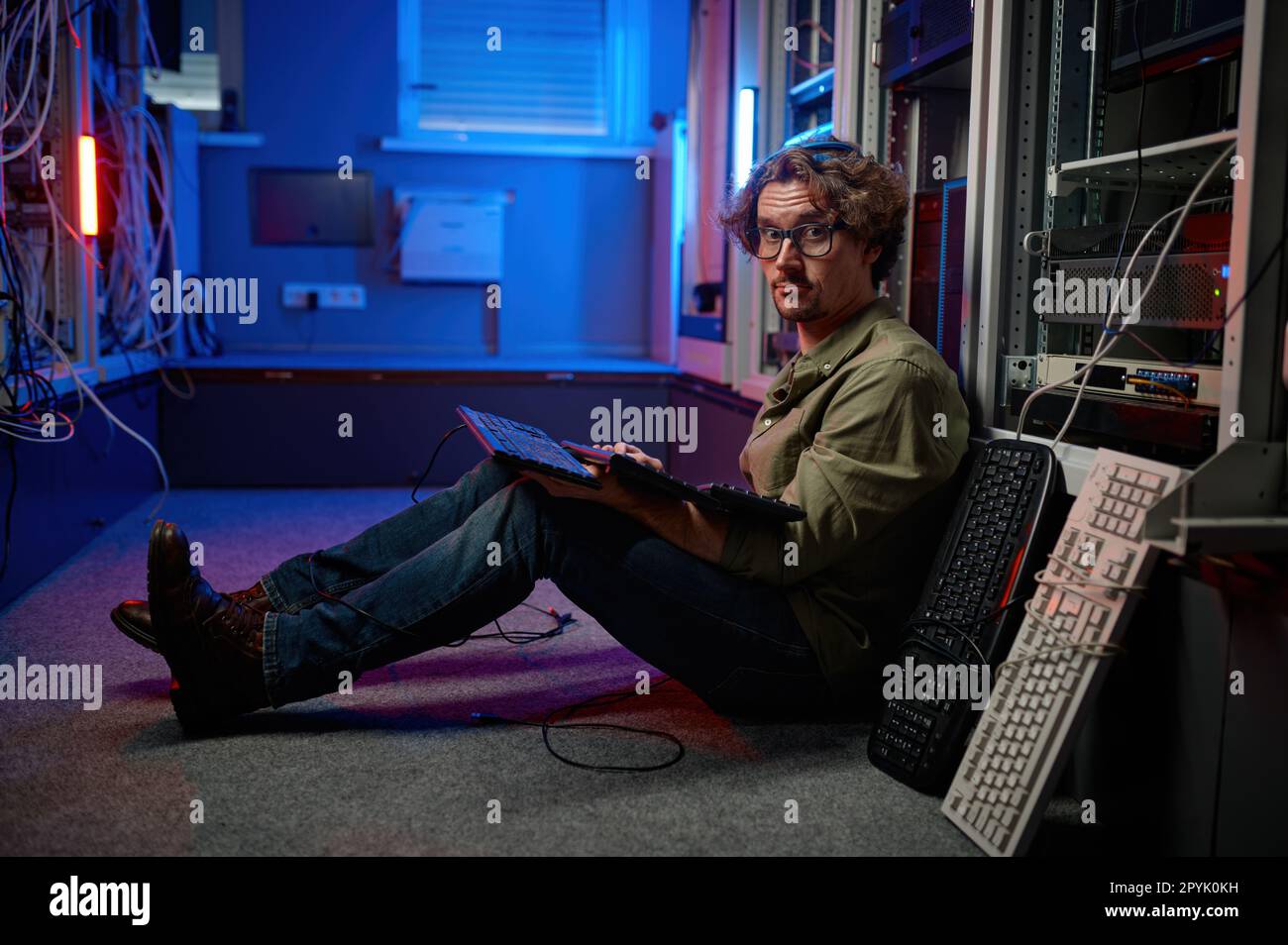 Ingegnere del data center che utilizza la tastiera nella sala server dei supercomputer Foto Stock