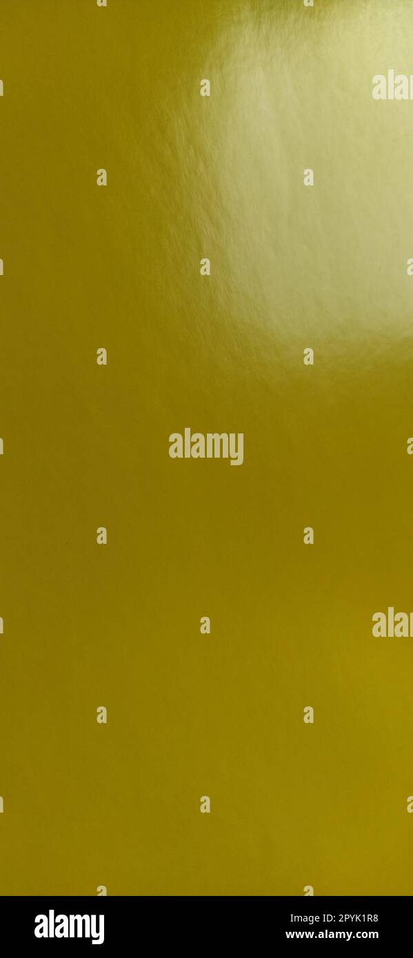 Bel fondo giallo. Primo piano di un foglio di carta. Colore puro e allegro. Tonalità di giallo brillante, simile a un colore scuro e brillante. Riflesso della luce su una superficie lucida. Foto Stock