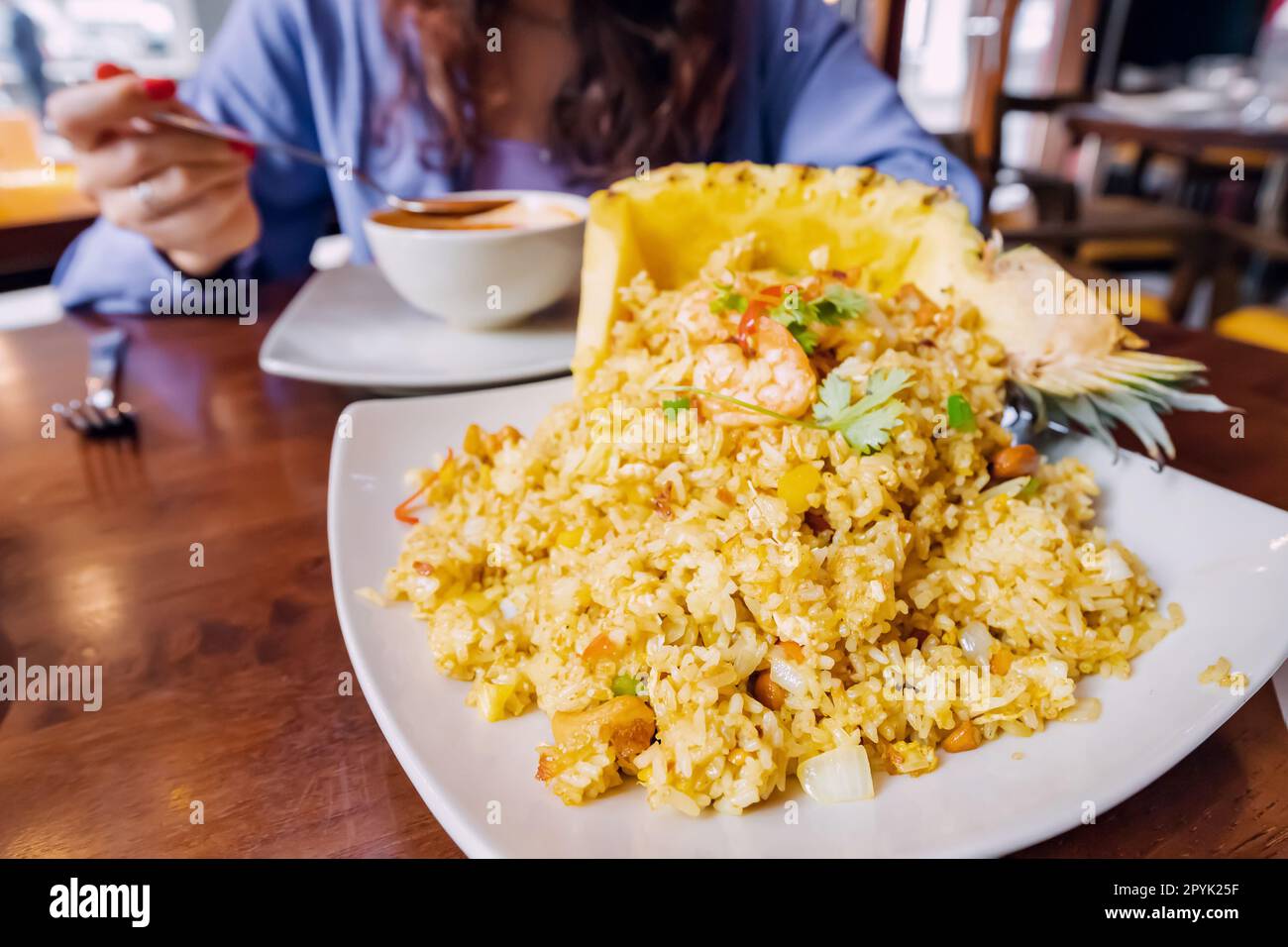Questo piatto di riso e ananas tailandese è una sinfonia di sapori dolci e salati che ballano attraverso la lingua. L'ananas succoso e piccante si abbina perfettamente Foto Stock