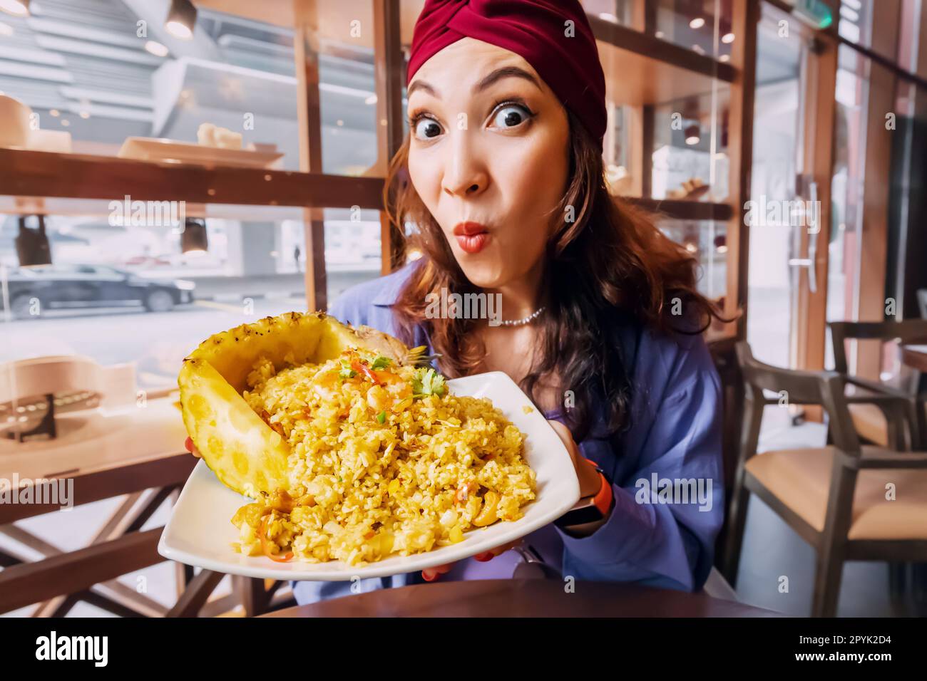 Ragazza felice con riso tailandese e ananas piatto, che è una sinfonia di sapori dolci e salati che danza attraverso la vostra lingua. L'ananas succoso e piccante Foto Stock