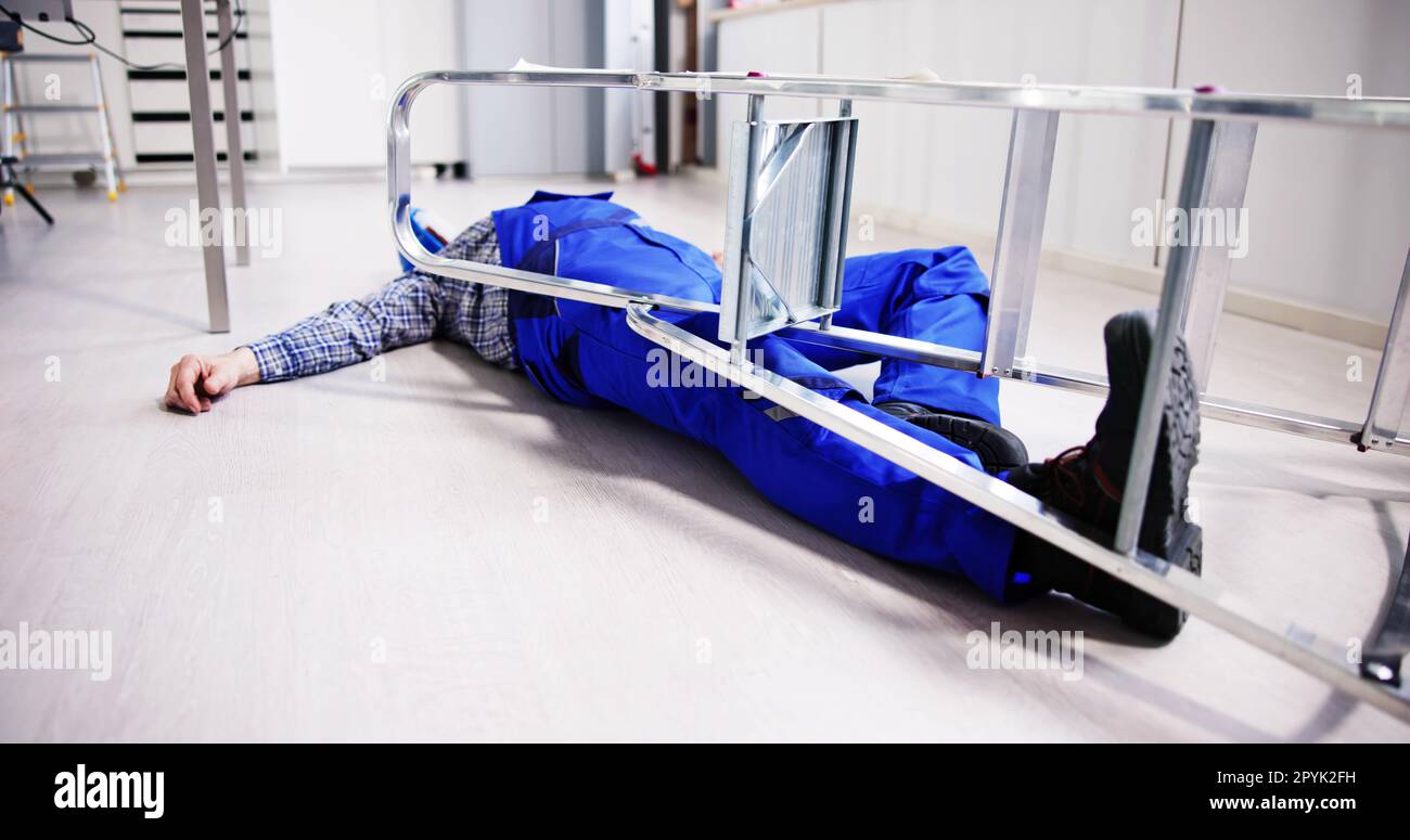 Uomo incosciente caduto dalla scala con attrezzature mentite Foto Stock