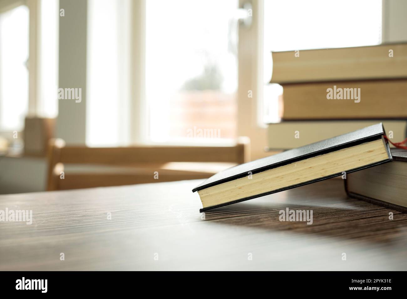 Concetto di apprendimento didattico con libro di apertura o libro di testo a casa in ufficio, pila di pile di testi di letteratura archivio accademico sulla scrivania di lettura e corridoio di scaffali nelle aule scolastiche interni di fondo della classe di studio Foto Stock