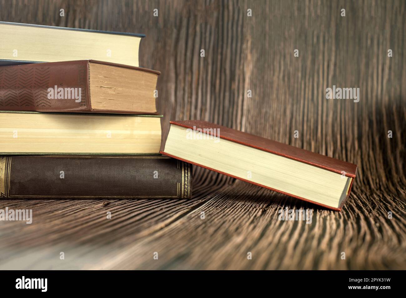 Concetto di apprendimento didattico con libro di apertura o libro di testo a casa in ufficio, pila di pile di testi di letteratura archivio accademico sulla scrivania di lettura e corridoio di scaffali nelle aule scolastiche interni di fondo della classe di studio Foto Stock