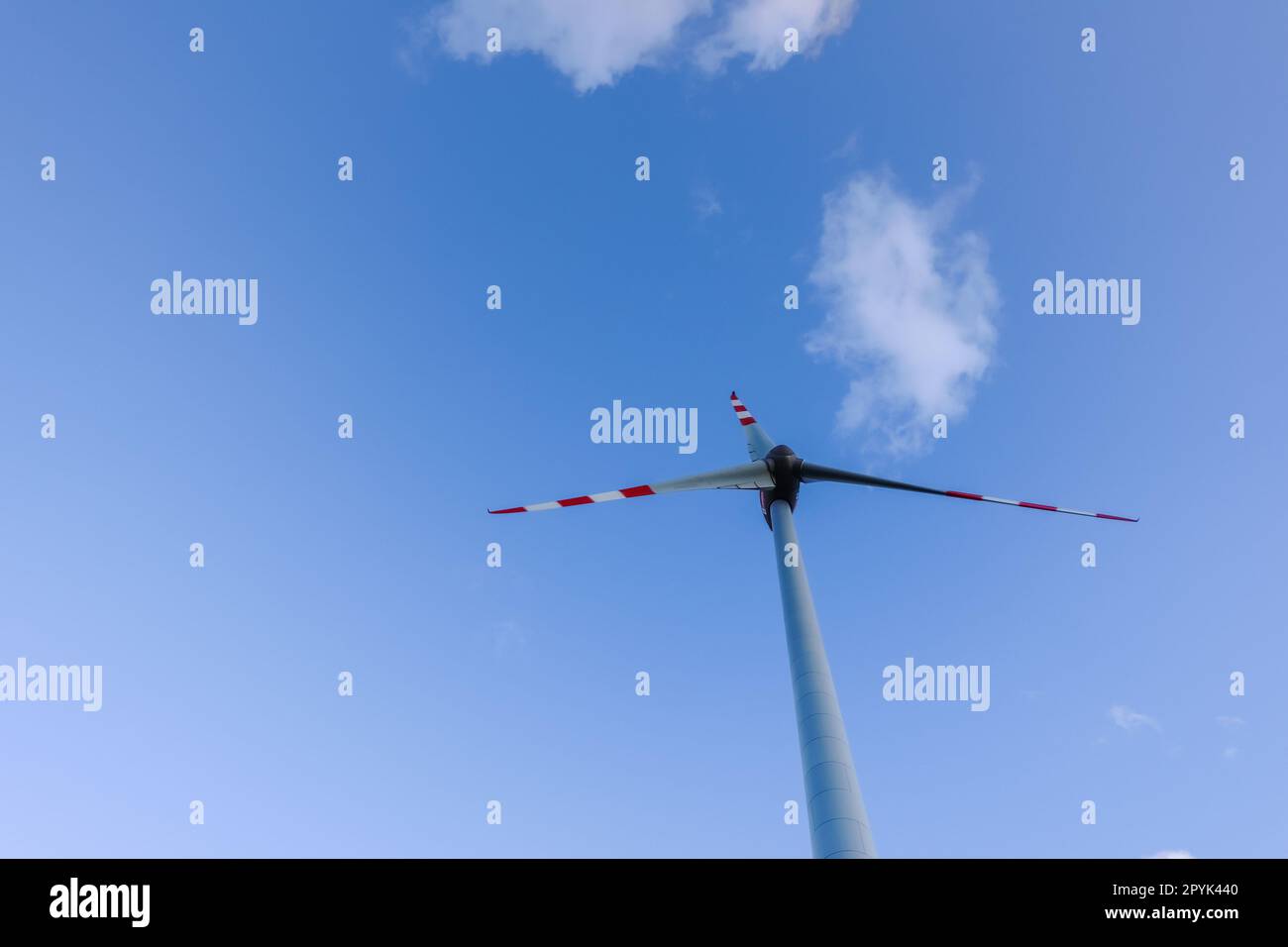 mulino a vento alto e nuvole morbide sul cielo blu per un'energia pulita Foto Stock