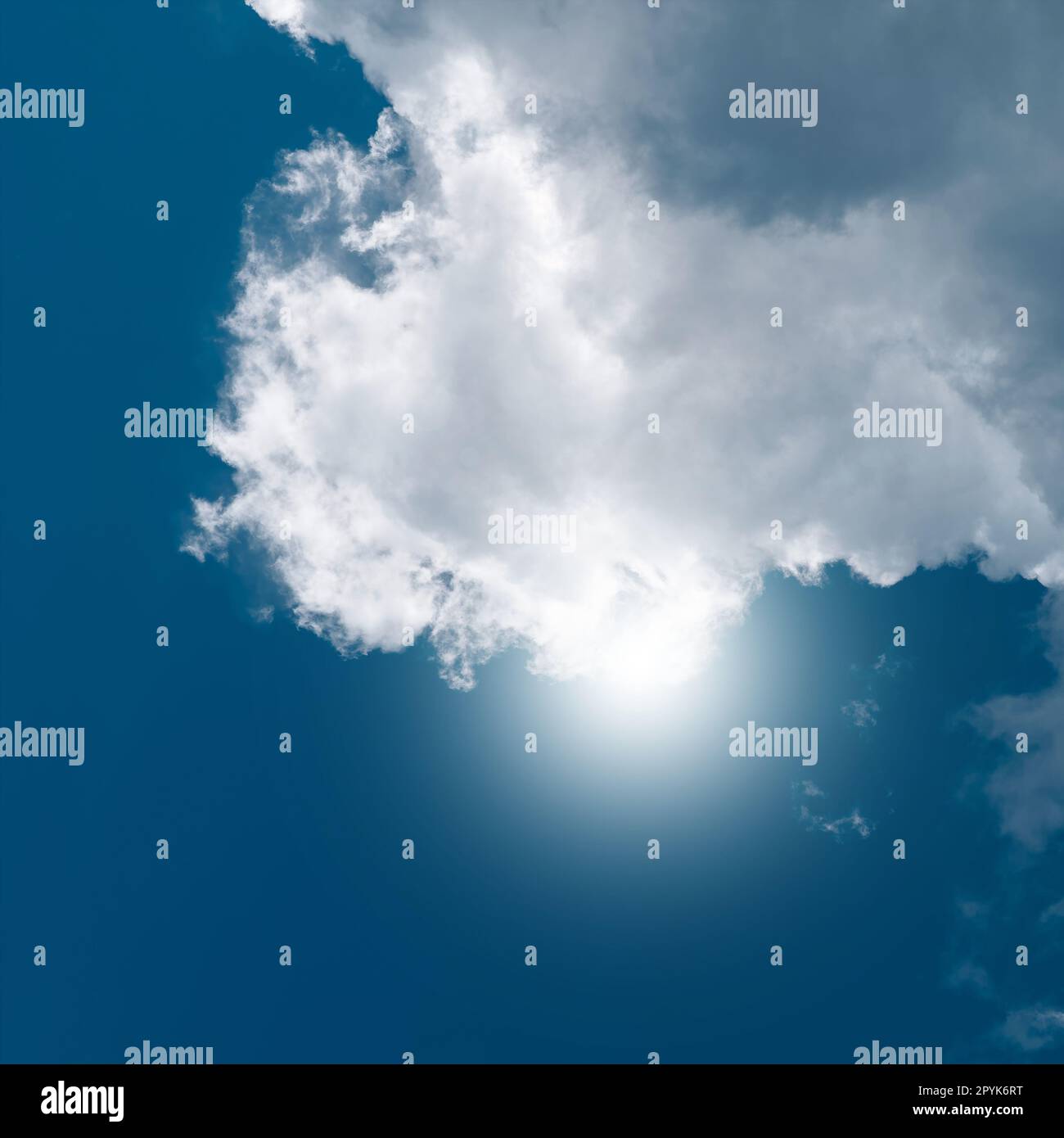 grande nuvola bianca con il sole sullo sfondo in una calda giornata estiva Foto Stock