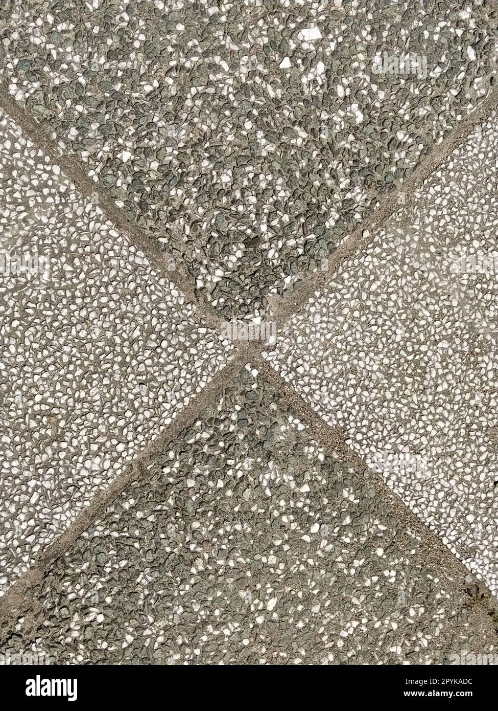 Linee diagonali. Piastrelle in pietra con rivestimento quadrato scuro e chiaro. Tessera scacchi. Marcature monocromatiche sull'asfalto sul campo sportivo. Primi piani quadrati o rombi. Superficie rocciosa ruvida. Foto Stock