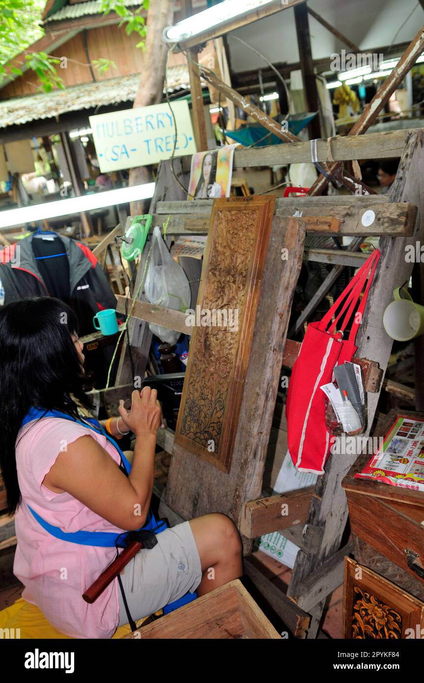 Un artista thailandese che scultura un rilievo di legno Foto Stock