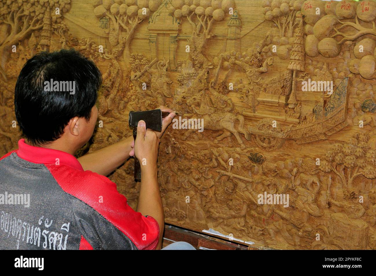Un artista thailandese che scultura un rilievo di legno Foto Stock