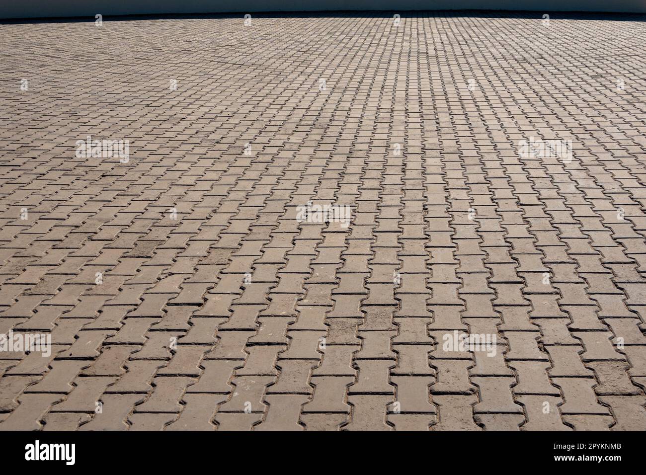 Ampia area di piccole pietre di pavimentazione esterne interbloccanti che svaniscono all'orizzonte Foto Stock
