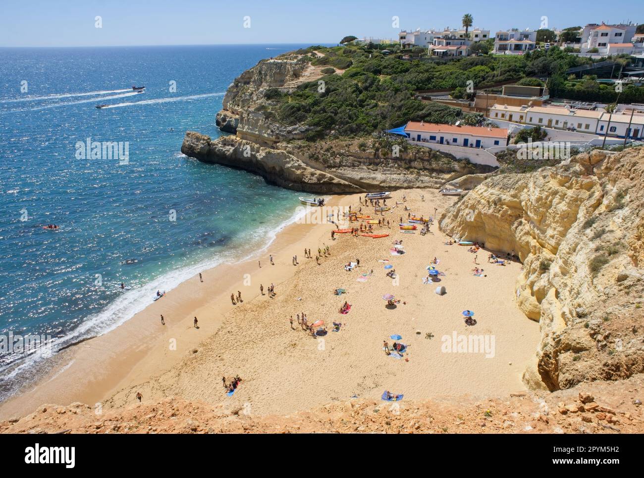Benagil, Portogallo - 11 aprile 2023: Paesaggi meravigliosi in Portogallo. Vista panoramica e colorata di Praia do Benagil nella regione dell'Algarve. Giallo roccioso Foto Stock