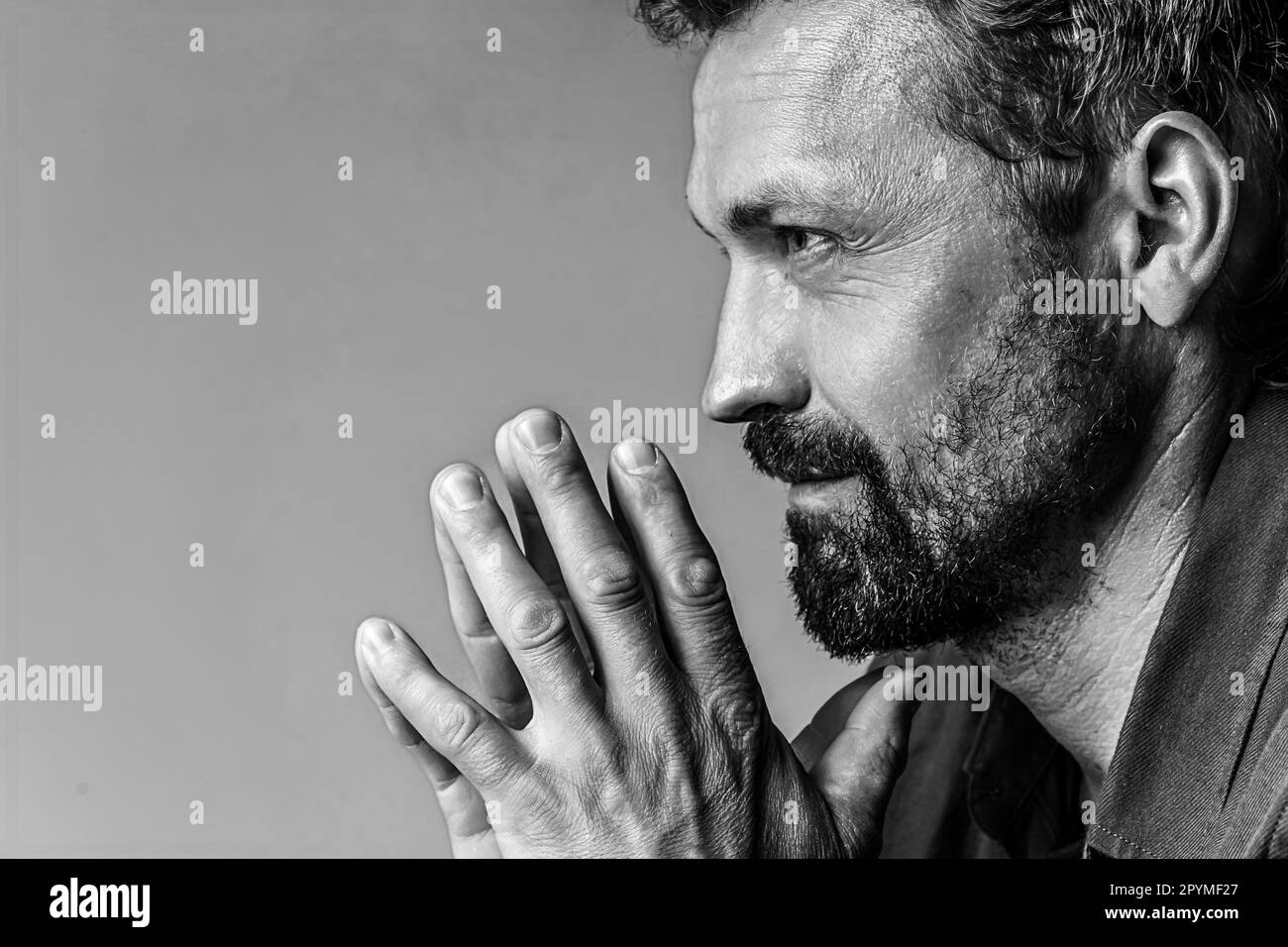 Brutale ritratto dell'uomo in studio fotografico su sfondo bianco in bianco e nero. Concetto bello. Foto di alta qualità Foto Stock