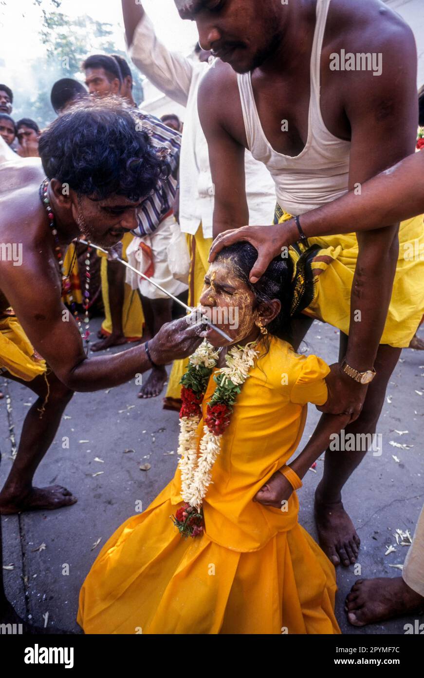 Il sacerdote pierces una faccia della ragazza con un festival di asta di ferro di lancia Mariamman a Coimbatore, Tamil Nadu, India del Sud, India, Asia Foto Stock