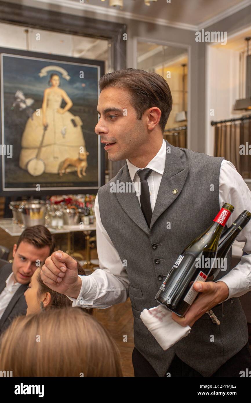 cameriere in uniforme che serve vino durante la festa, l'evento festivo o il matrimonio al coperto Foto Stock