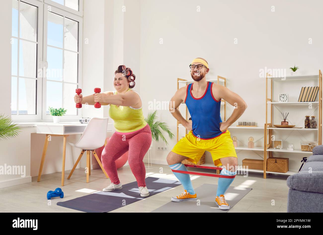 Donna grassa sovrappeso con uomo bearded divertente in sportswear luminoso che fa le esercitazioni nel paese insieme. Foto Stock