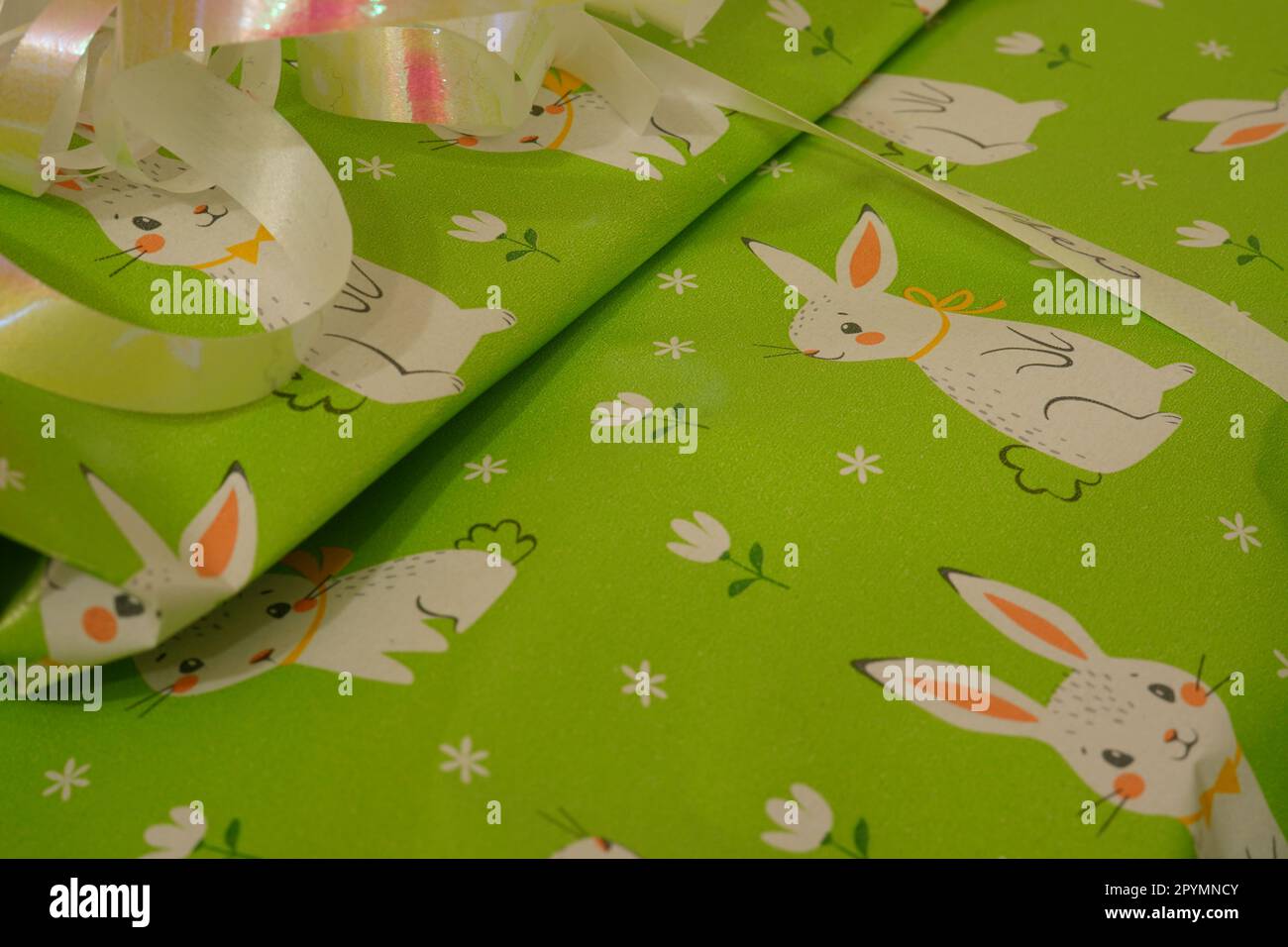 Un foglio di carta da imballaggio verde chiaro con due vignette di Pasqua coniglietti Foto Stock